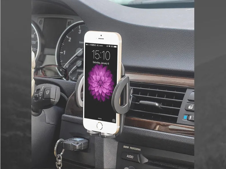 Black plastic mobile phone holder mounted on car air conditioning outlet with phone inserted