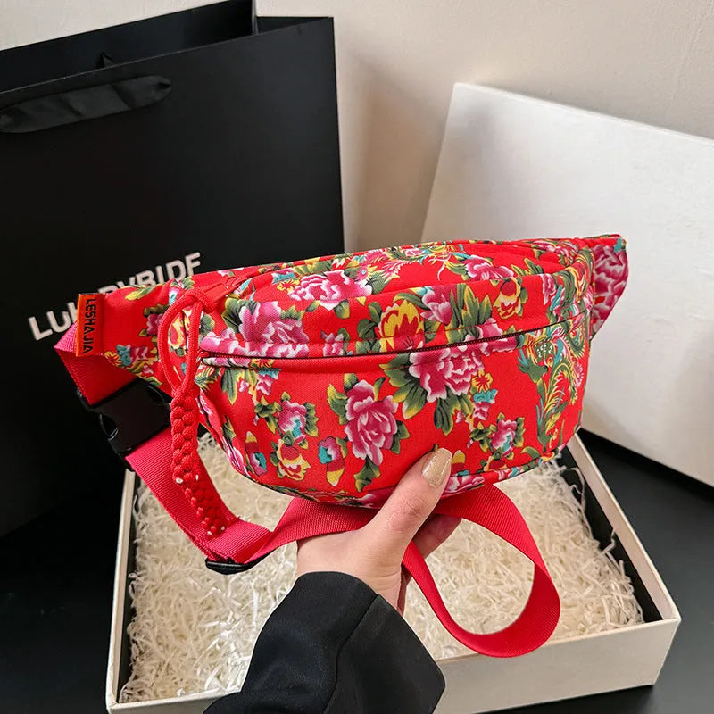 Women's black waist bag with large red flower design and western stitching details.