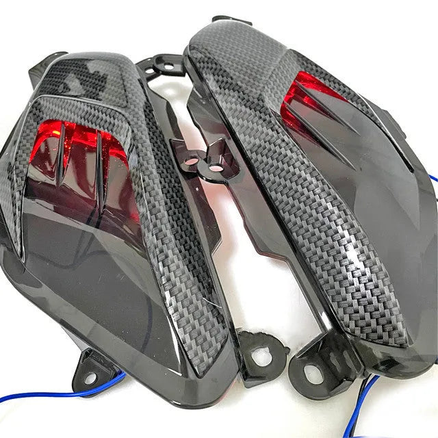 Pair of carbon fibre-style side lamp assemblies for Yamaha NMAX scooters with blue LED illumination option.