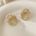 Gold-coloured copper flower basket earrings with small bead and pearl inlay detail.