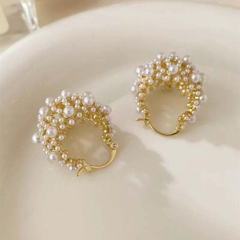 Gold-coloured copper flower basket earrings with small bead and pearl inlay detail.