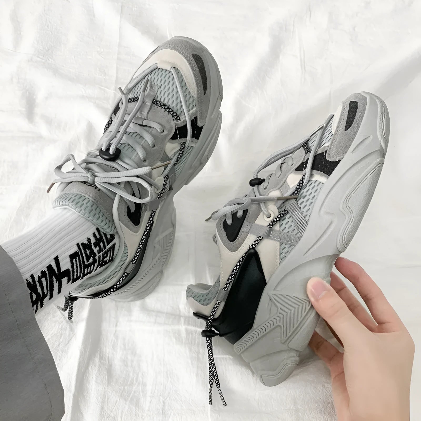 Men's white platform dad sneakers with a lace-up front and thick sole, shown on a grey background.