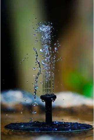 Black solar-powered floating fountain pump with four spray nozzles on a solar panel for garden ponds