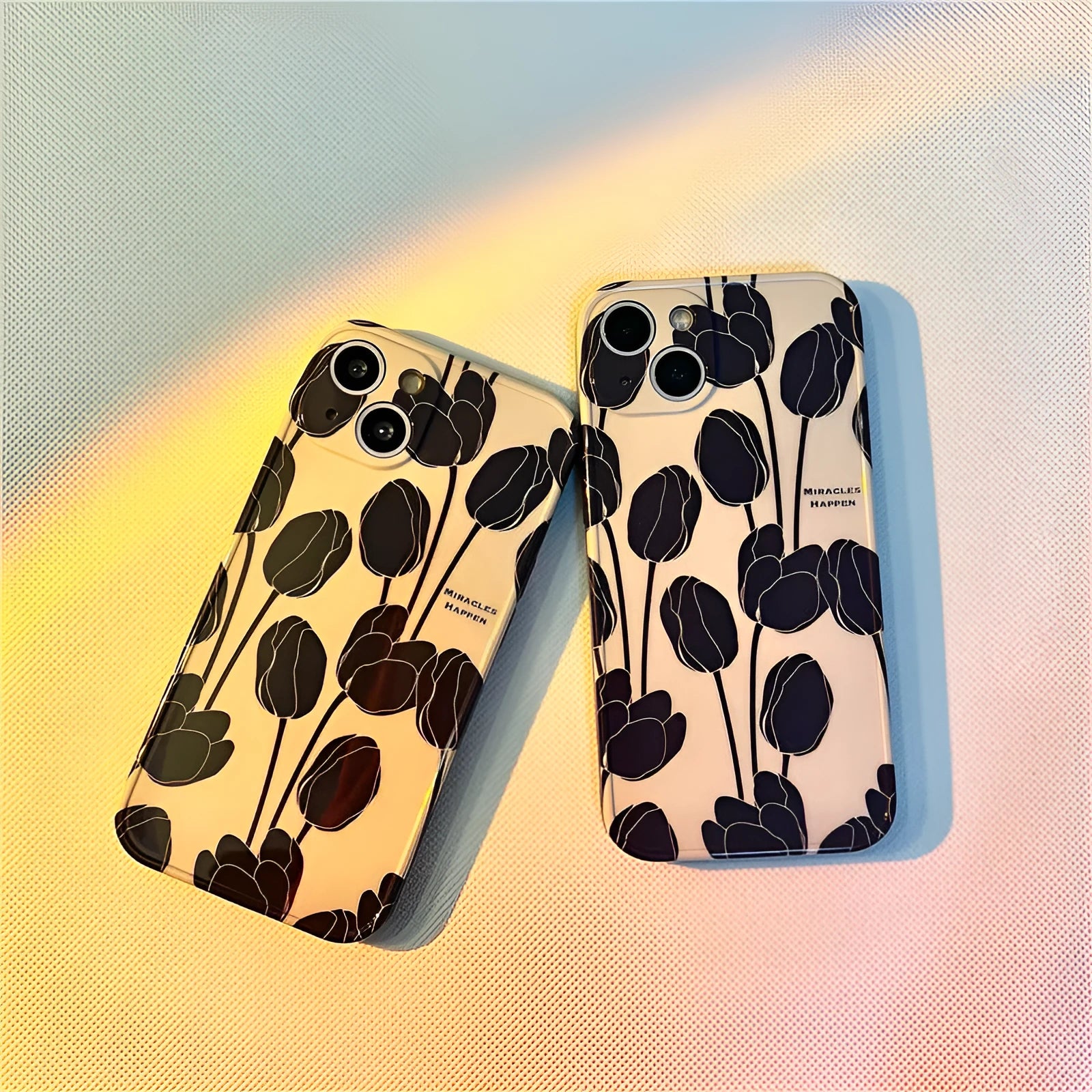 Black silicone iPhone case with a white tulip pattern design on the back.