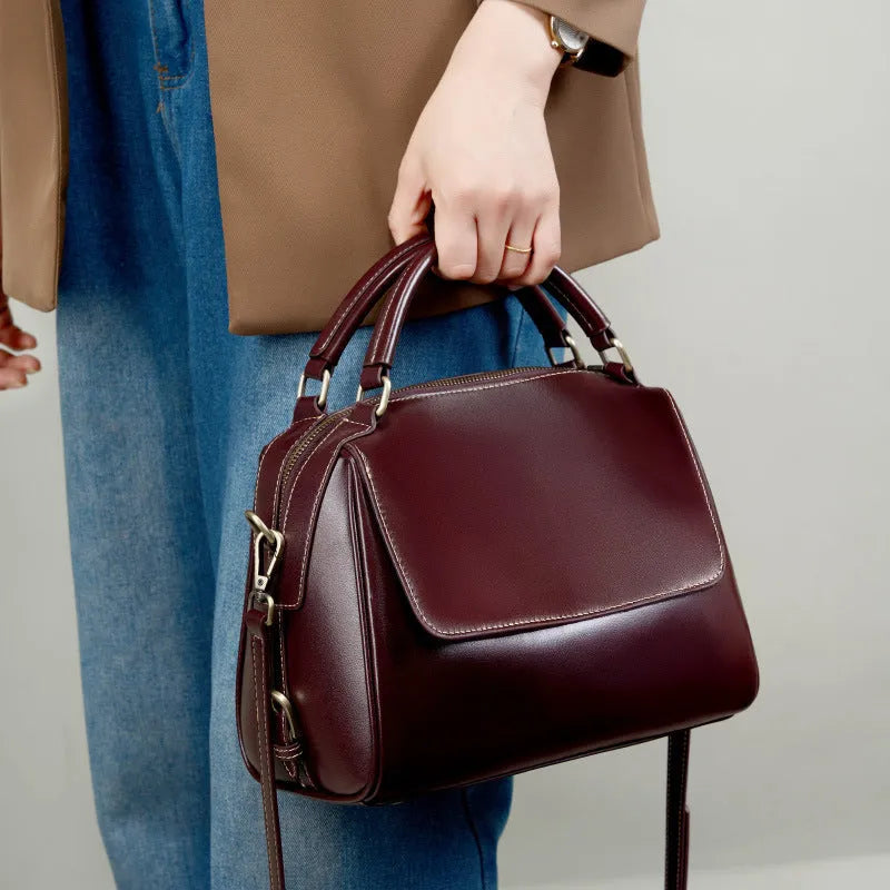 Women's soft cowhide leather crossbody tote bag in apricot colour, showing internal zip pockets and double shoulder strap.
