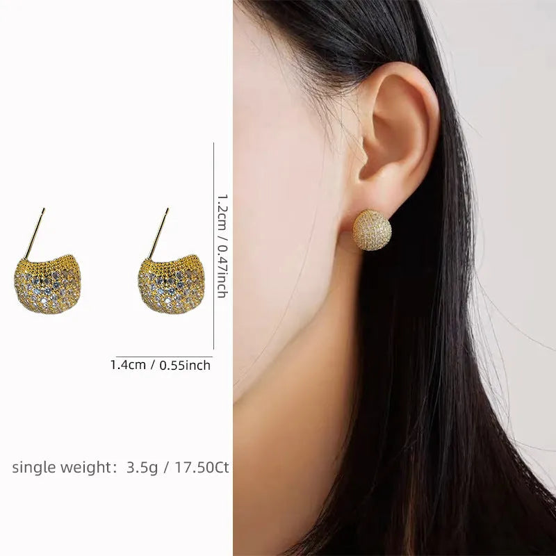 Gold geometric drop earrings with spherical elements and diamond detailing on clip-on backs