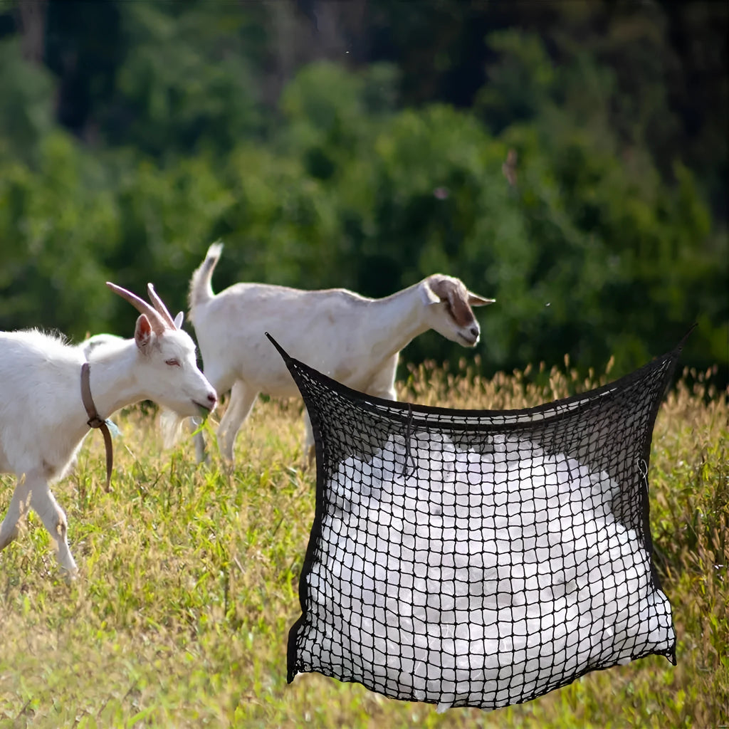 Black woven grid horse feeding bag hanging, filled with hay, for cattle or sheep.