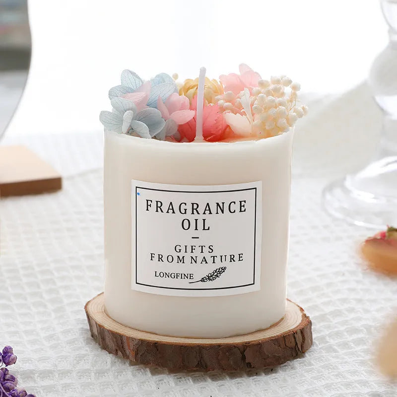 Aromatherapy candle decorated with dried flowers on top, shown in gift box packaging with a wood base.