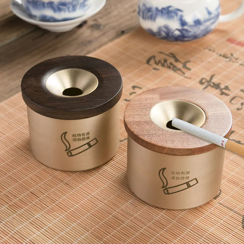 Brass ashtray with a wooden lid featuring a central hole, shown in black wood and red wood options.