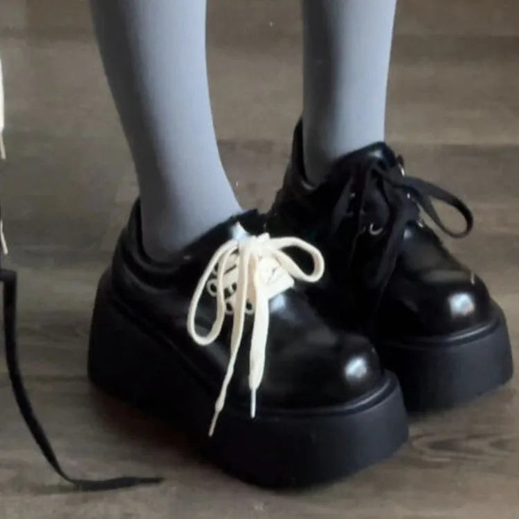 Women's matte black lace-up ankle boots with a thick rubber sole and a chunky heel on a white background.