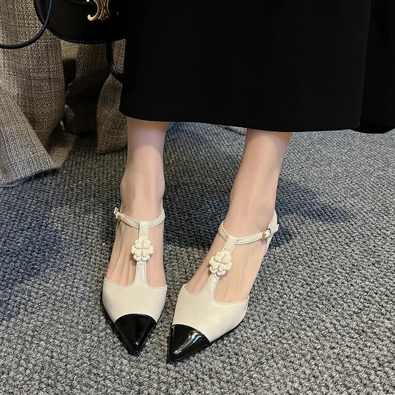 Women's black stiletto heel pointed toe shoe with floral buckle on sheepskin leather upper.