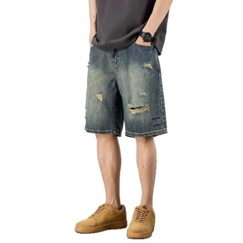 Blue denim men's shorts with distressed holes and straight cut design on mannequin
