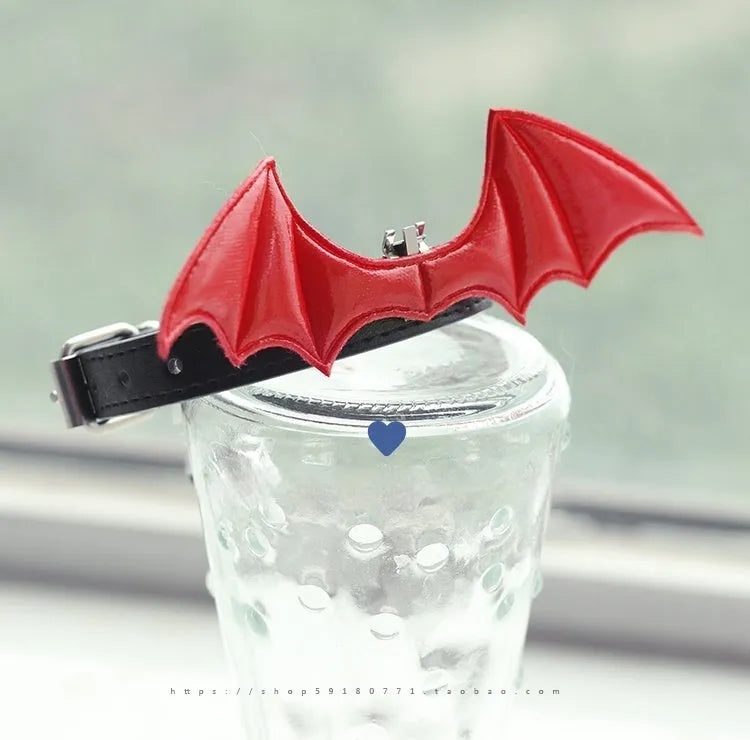 Small leather dog collar with decorative devil wings and bell in patent leather satin