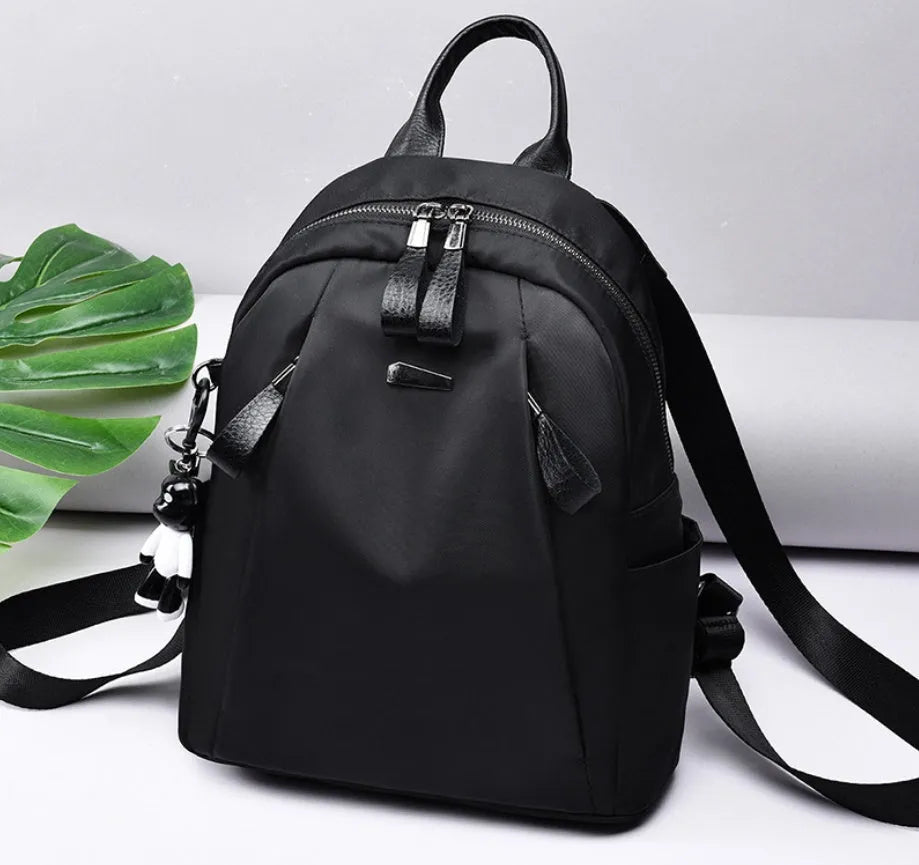 Medium-sized wine red Oxford cloth rucksack with double straps and a soft handle.