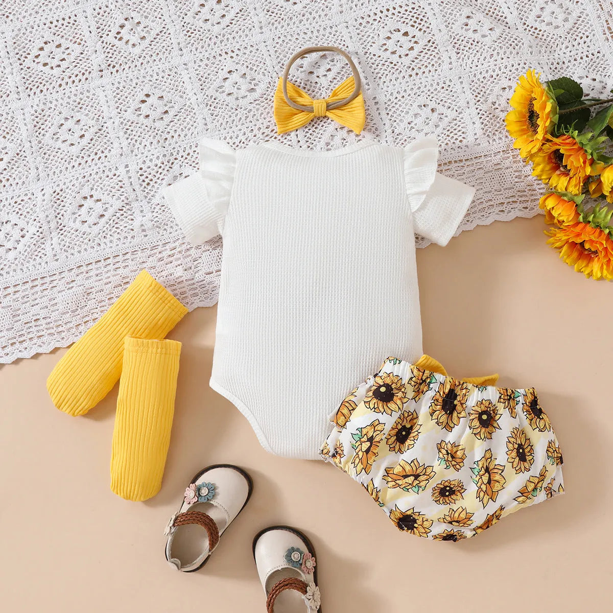 Baby girl yellow triangle ruffled shorts suit with white blouse and bow detail on baby model