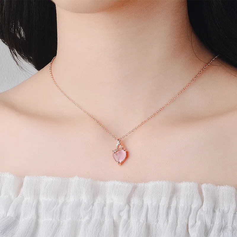 Women's rose gold heart pendant necklace with pink crystal on cross chain