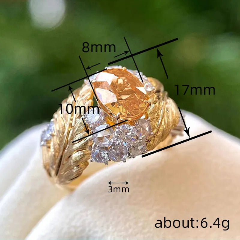 Gold coloured copper feather ring with embossed design and yellow zircon stone.