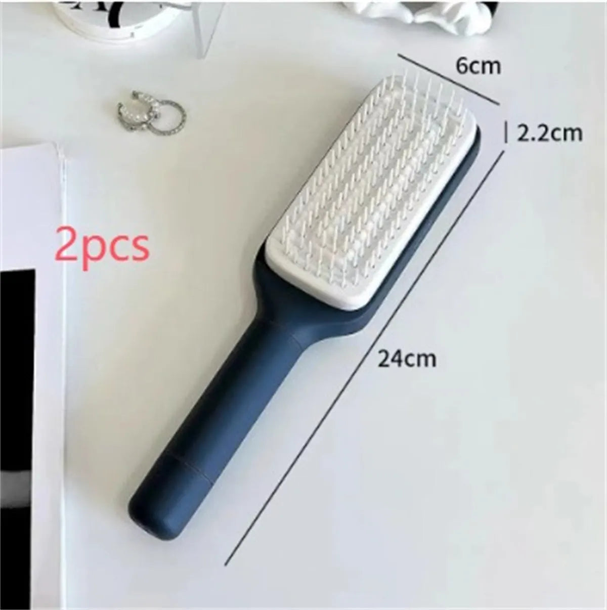 Self-cleaning hair brush with rotating handle, anti-static teeth and scalp massage points in purple and grey colours