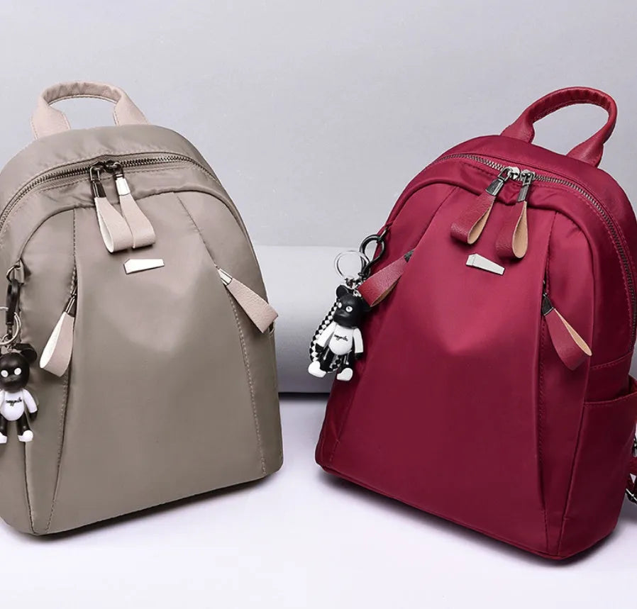 Medium-sized wine red Oxford cloth rucksack with double straps and a soft handle.