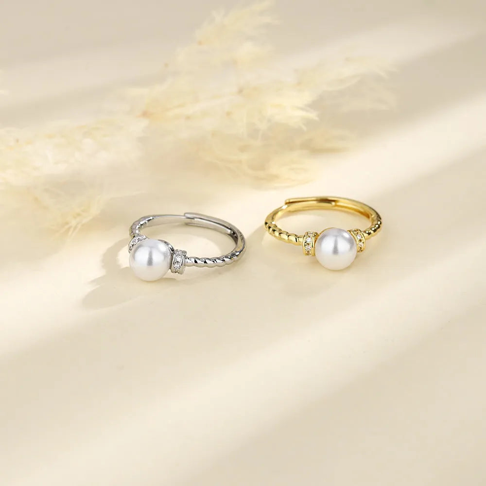 Adjustable antique twist ring with a pearl inlay, shown in gold and silver copper finish.