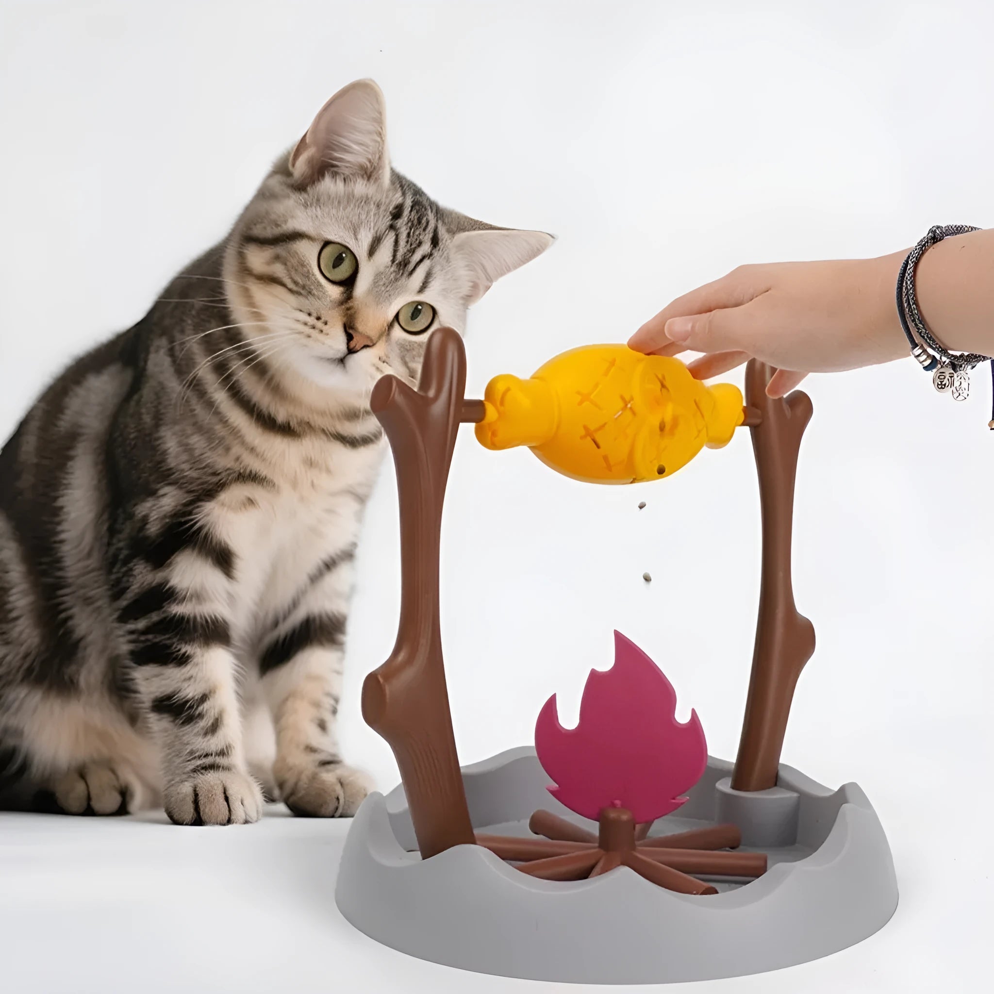 Barbecue-style tumbling interactive cat feeder toy with food compartments, 30cm cube.