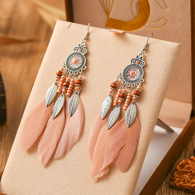 A pair of bohemian-style round drop earrings with a feather leaf pattern, shown in one of thirteen available colours.