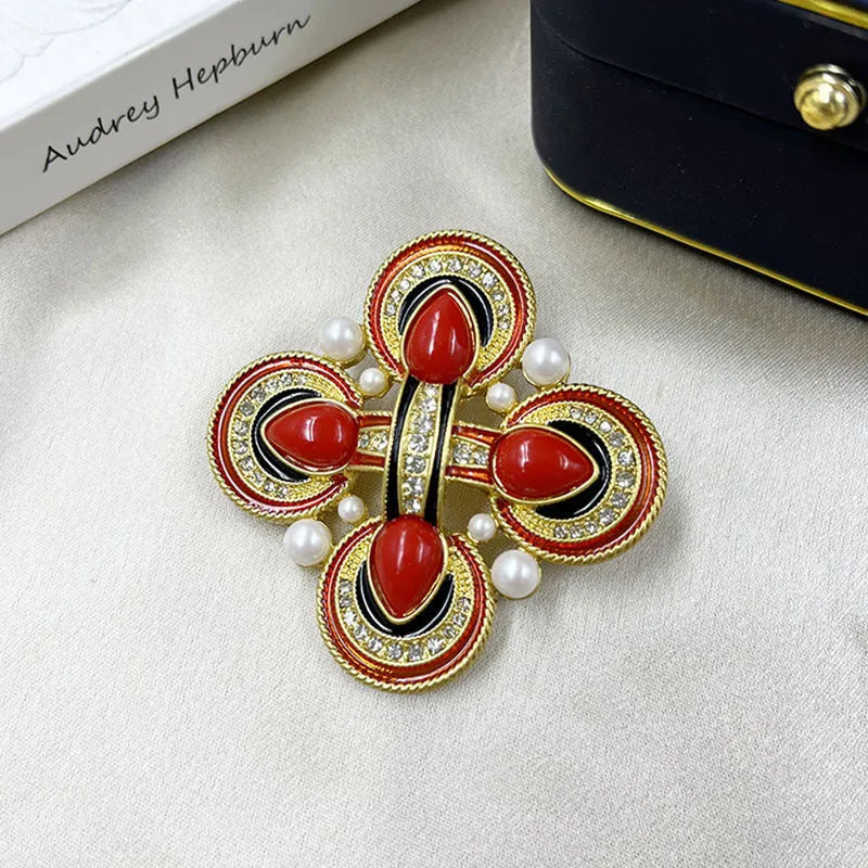 Close-up of a medieval-style baroque cross brooch with crystal decoration on a metal base.