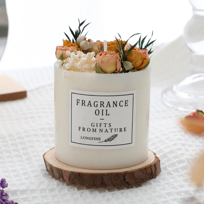 Aromatherapy candle decorated with dried flowers on top, shown in gift box packaging with a wood base.