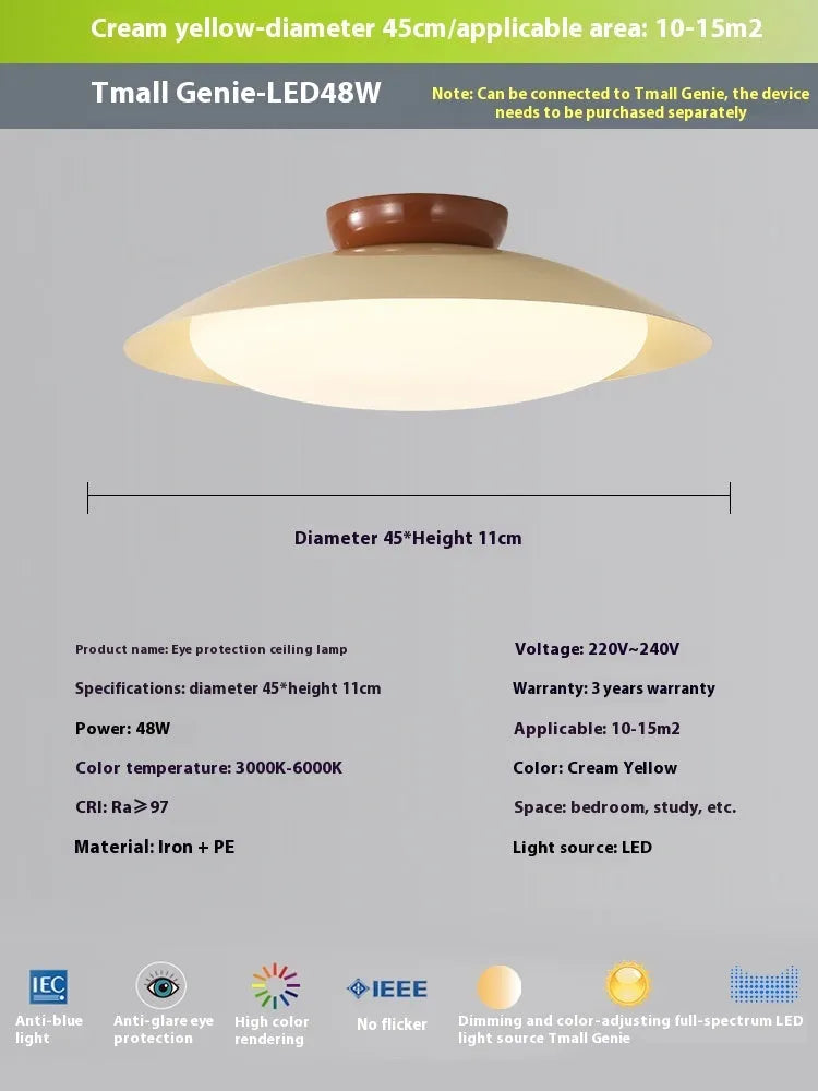 Modern minimalist flying saucer design ceiling lamp in cream yellow on a white ceiling.