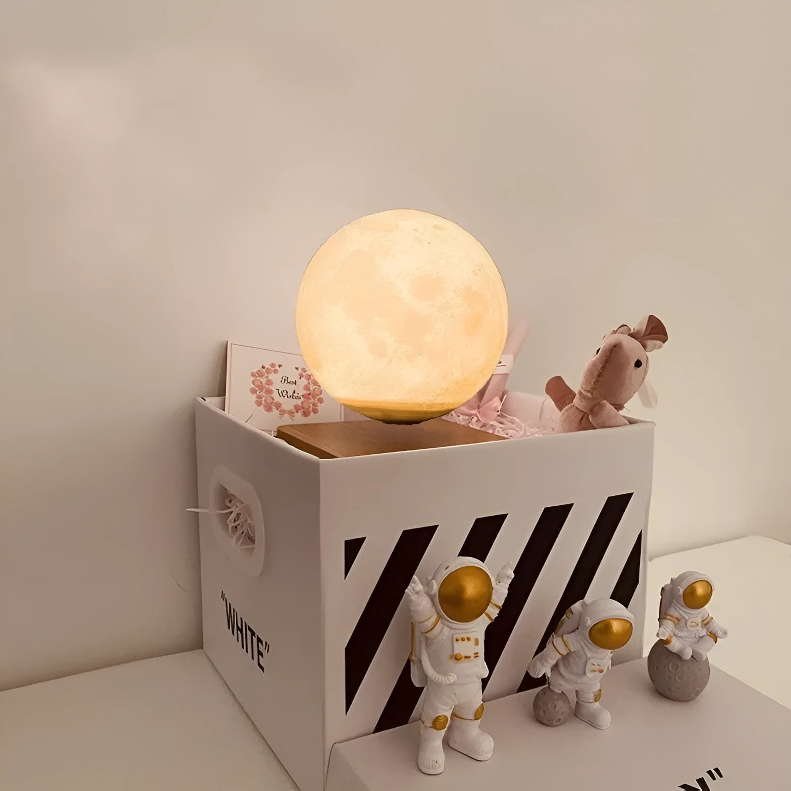 Maglev floating moon and earth night light with LED glow and small astronaut figurines on a table.