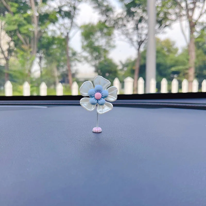 Small colourful plastic swing car decoration hanging ornament in blue, green, pink, purple, or yellow.