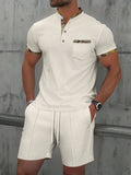 Man wearing a grey waffle knit zip-up polo collar tracksuit with matching shorts for summer leisure.