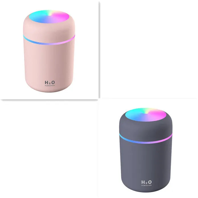 Pink USB desktop humidifier with coloured lights and water tank on a wooden desk