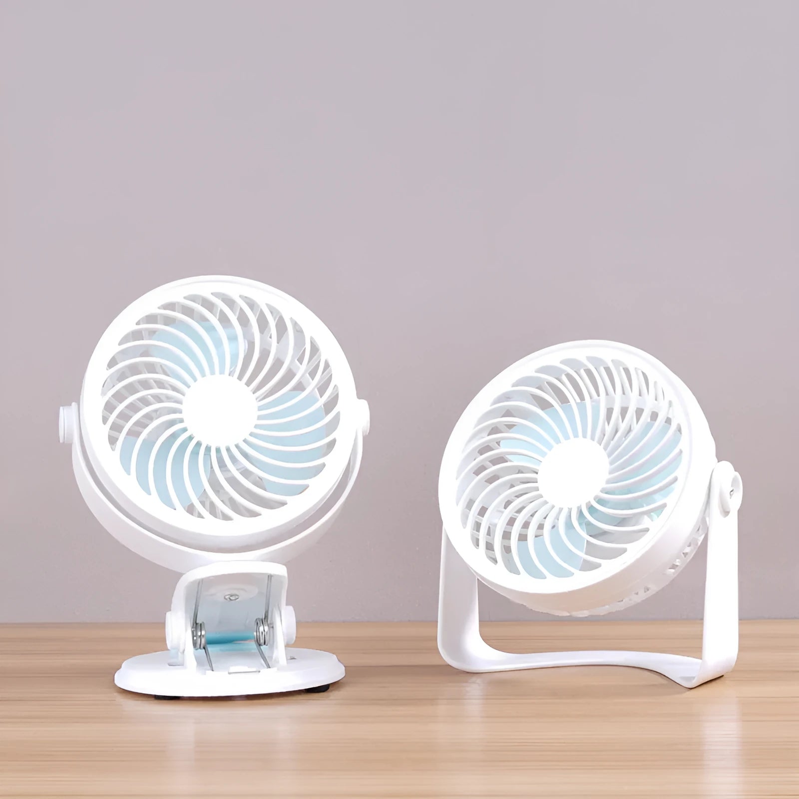 Compact USB desktop fan shown as both a clip-on model and a floor-standing model on a wooden desk.