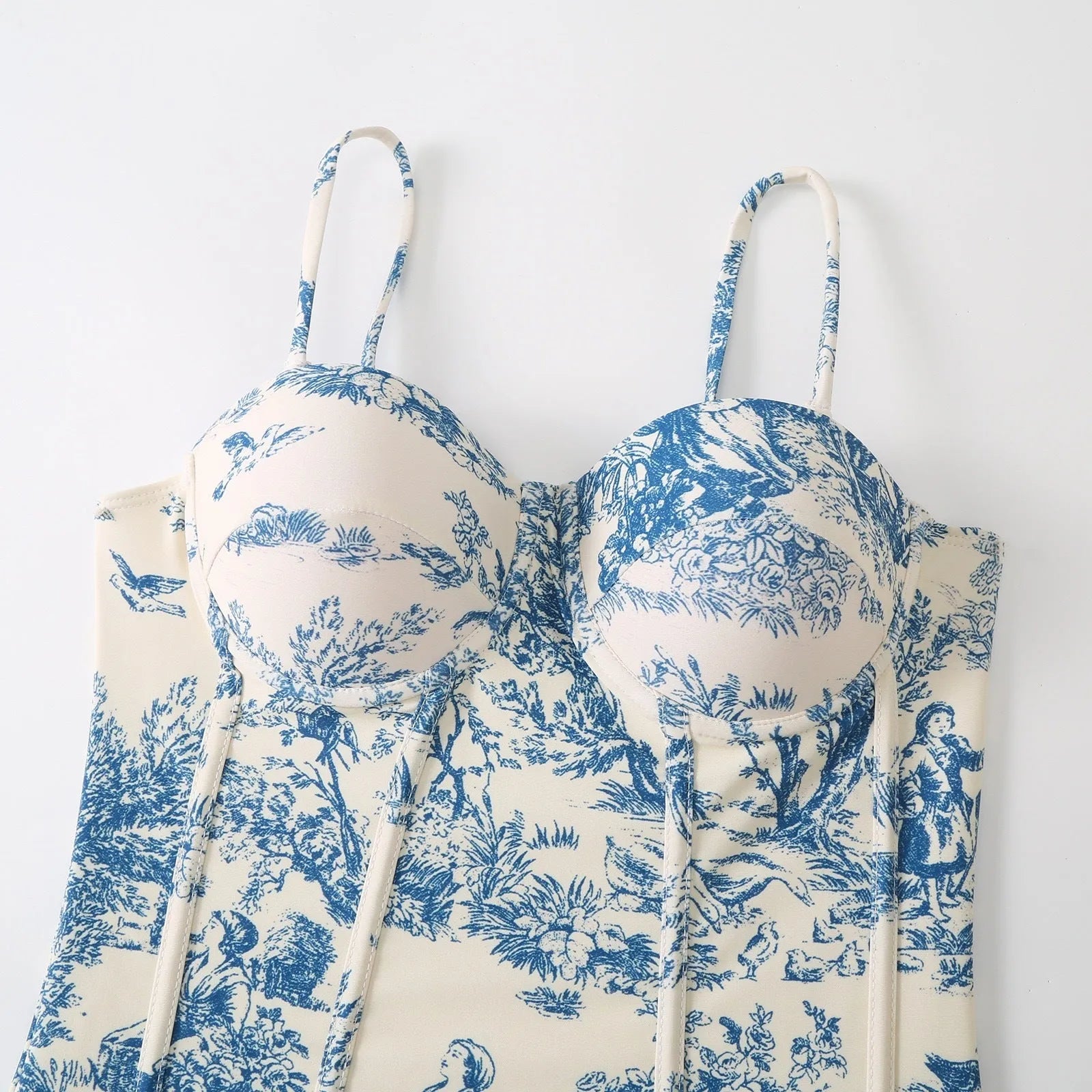 Blue women's one-piece swimsuit with a matching gauze skirt on a size chart background