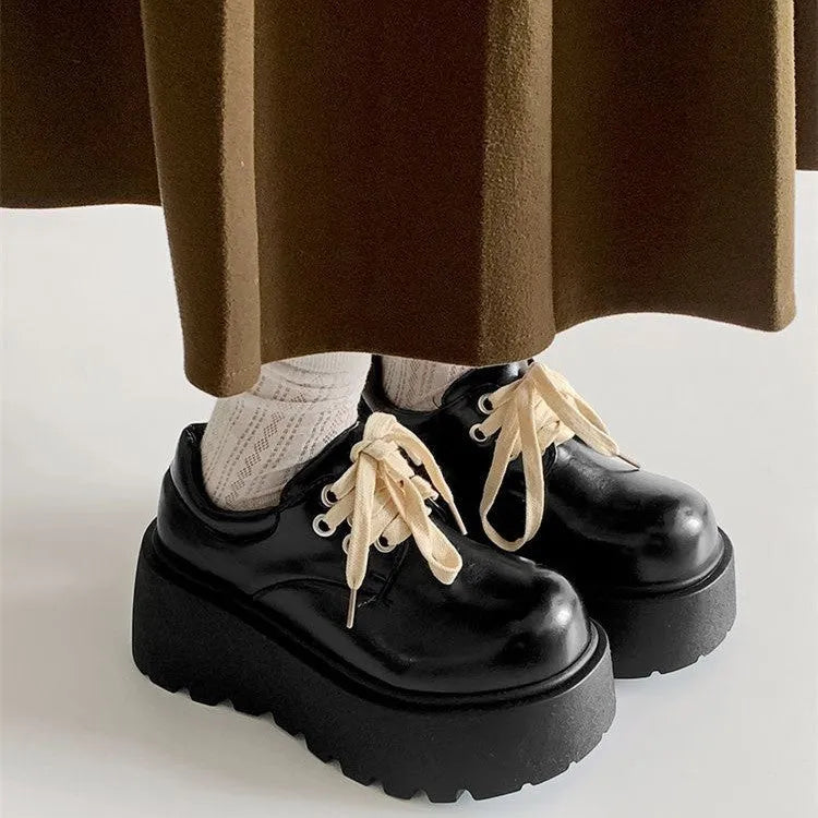 Women's matte black lace-up ankle boots with a thick rubber sole and a chunky heel on a white background.