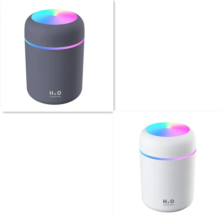 Pink USB desktop humidifier with coloured lights and water tank on a wooden desk