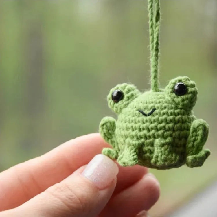Handmade woven car pendant with a green frog plush doll hanging.
