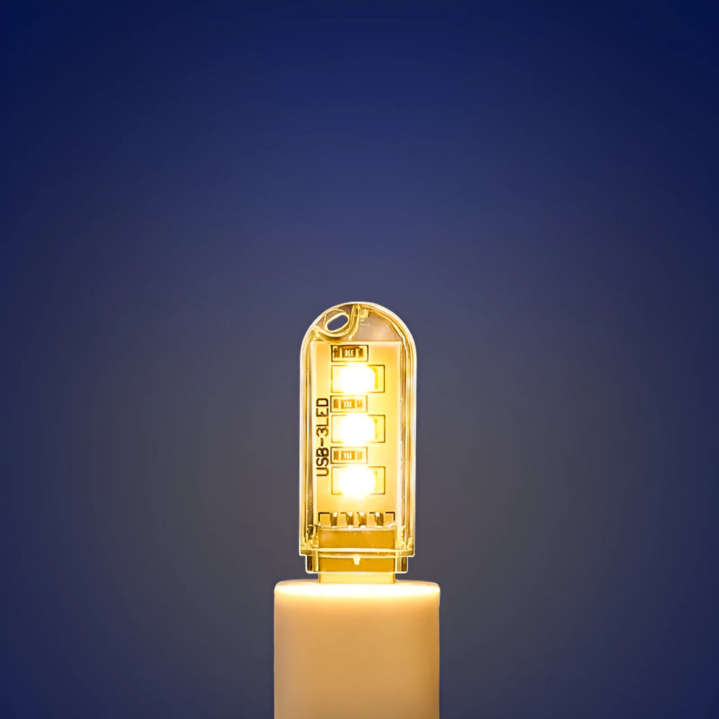 Small cylindrical USB baby night light showing warm yellow glow on a dark background.