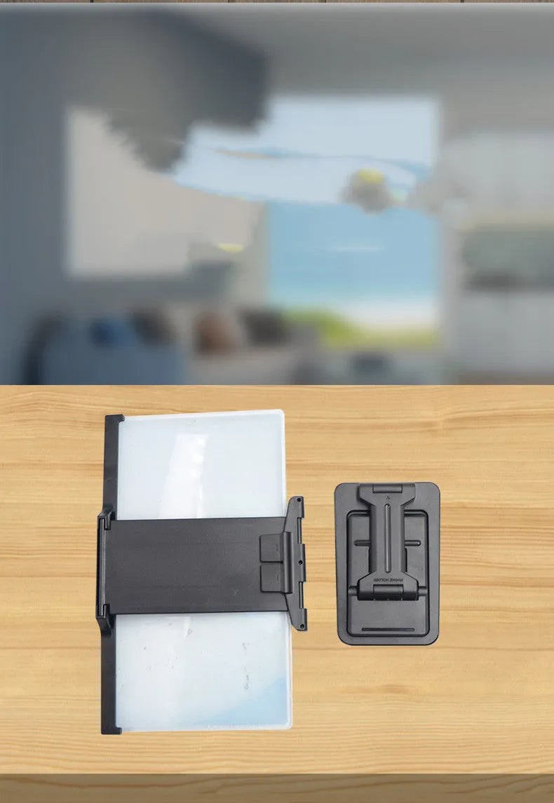 Black folding mobile phone screen magnifier with detachable holder on a desk