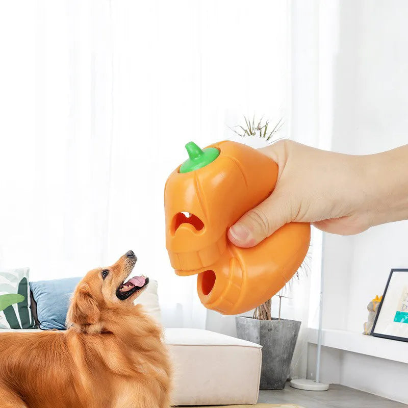 Orange Halloween pumpkin-shaped rubber dog chew toy with a treat-dispensing funnel hole.