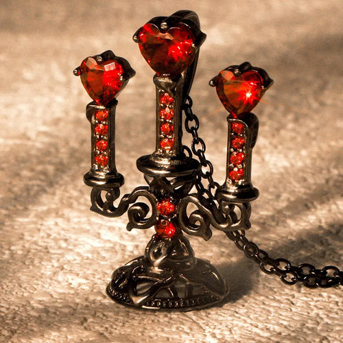 Close-up of a retro-style hollow candlestick pendant necklace with a cross chain, in a gothic design.