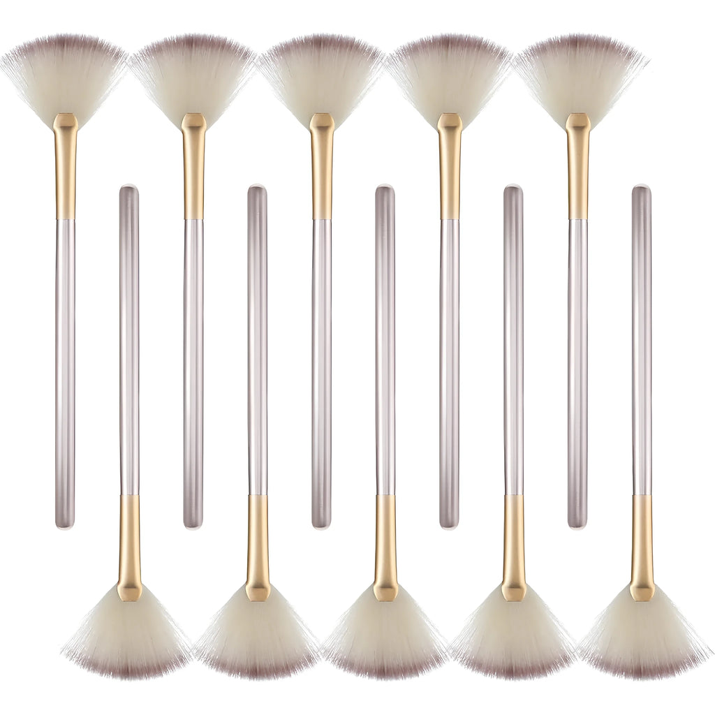 Ten champagne-coloured facial fan brushes with acrylic handles and protective covers laid out.