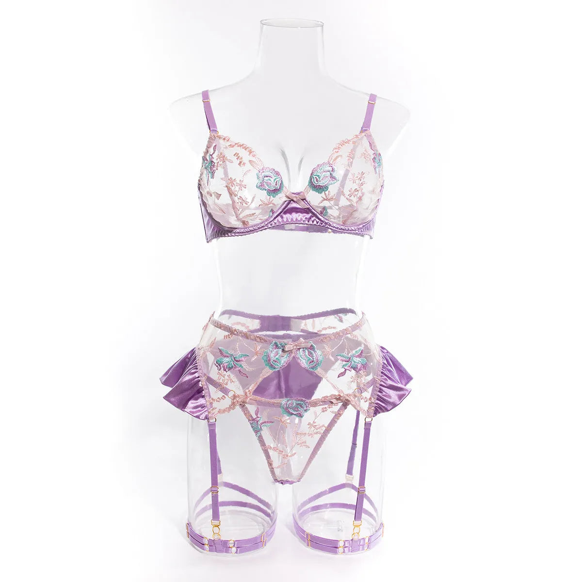 Light purple satin four-piece lingerie set laid flat, showing the three-point style and delicate fabric texture.