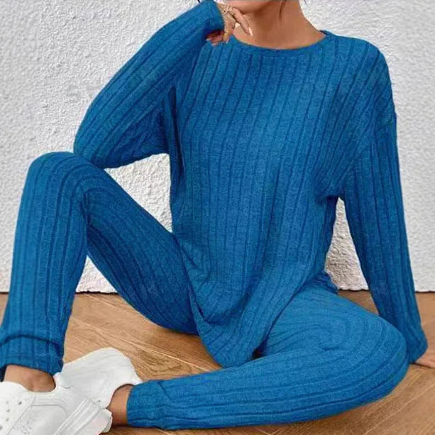 Women's black two-piece lounge set with a sunken stripe pattern on the top and matching trousers.