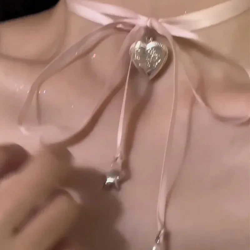 Women's ribbon pendant necklace with alloy chain and electroplated finish showing clavicle length