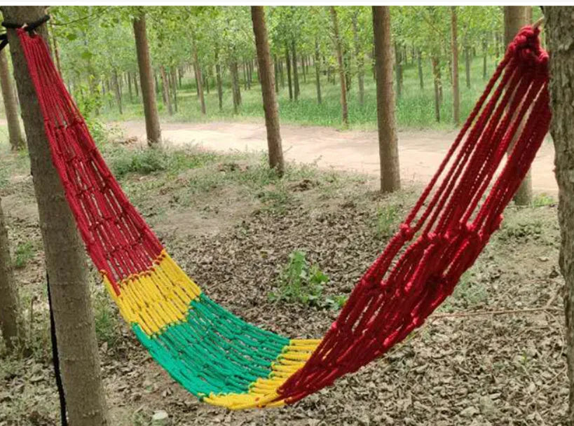 Nylon rope mesh hammock suspended between trees showing mesh pattern and included tying equipment