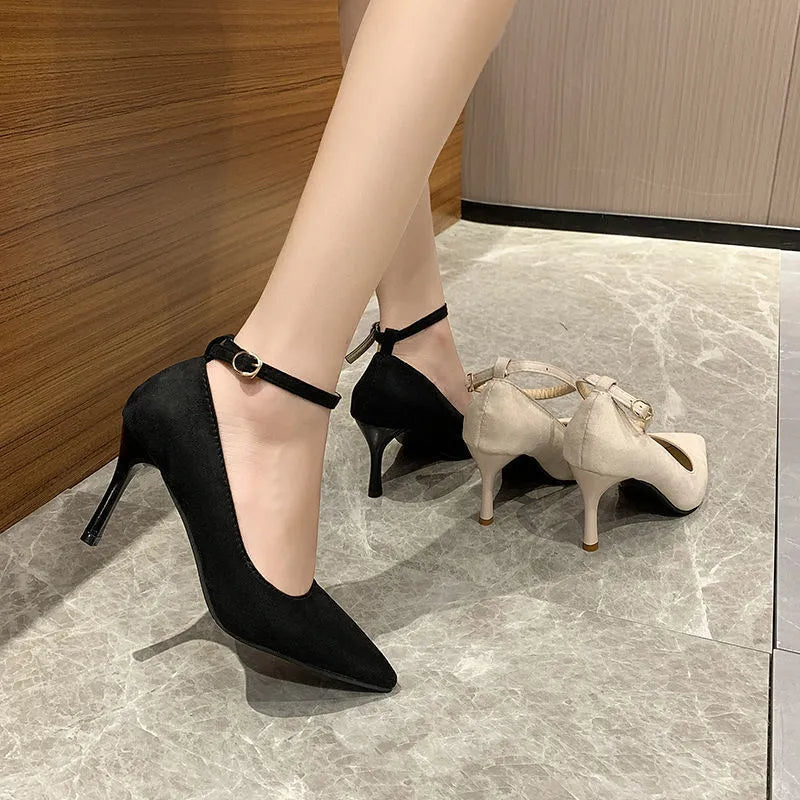 Black women's stiletto heel pump shoes with a skull pattern and ankle buckle on a rubber sole.