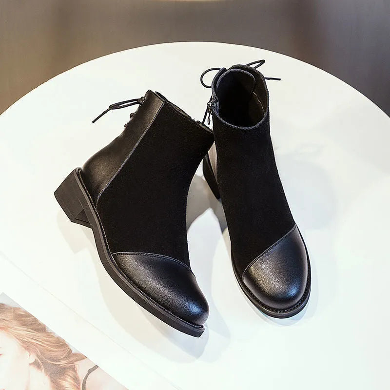 Black women's knee-high Martin boots with side zip and round toe on a short stout heel.