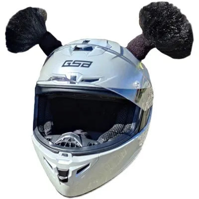 Pair of decorative braided balls for helmet customisation next to a tube of adhesive